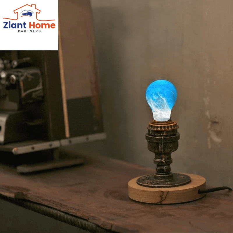 Retro style wooden desk light with an antique base and a glowing blue light bulb by Ziant Home Partners.