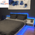 Bedroom with LED Smart Strip Lights creating a blue glow around bed, highlighting modern decor and abstract wall art.